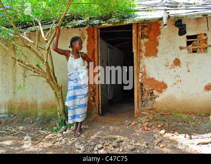 Femme debout par sa maison dans les régions rurales de Côte d'Ivoire Banque D'Images