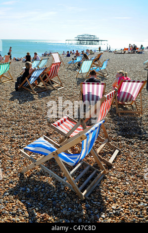 Transats sur la plage de Brighton West Pier et front de mer avec une distance en UK Banque D'Images