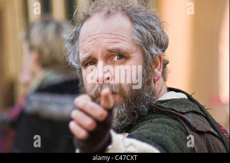 Homme vêtu de vêtements de style médiéval pointant vers la caméra lors d'un événement en plein air ou d'une reconstitution. Banque D'Images