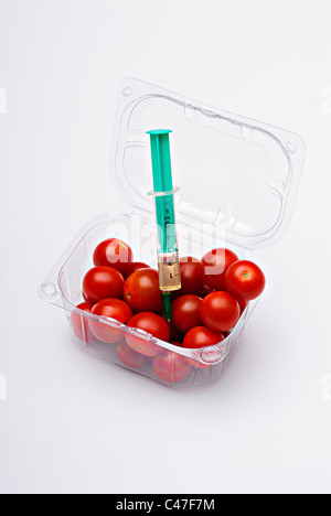 Tomates cerises en boîte en plastique clair avec injection seringue Banque D'Images