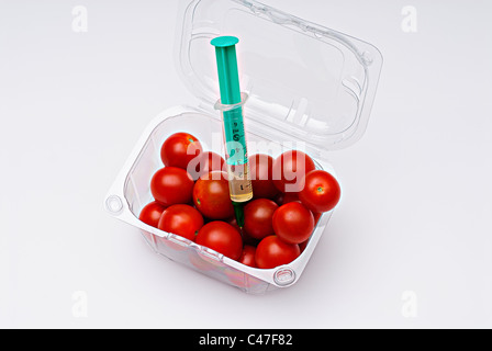 Tomates cerises en boîte en plastique clair avec injection seringue Banque D'Images