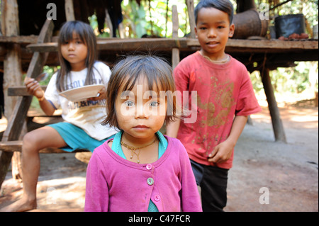 3 enfants cambodgiens une partie d'un peuple semi-nomade, connu sous le nom de hilltribe Bunongs tribu manger et jouer dehors. Banque D'Images