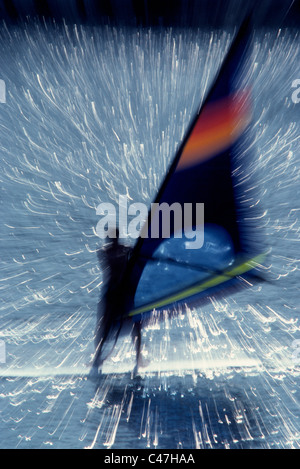 Le mouvement d'un windsurfer est renforcée par le zoom l'objectif de l'appareil pendant l'exposition pour illustrer l'action de ce sport d'eau. Banque D'Images
