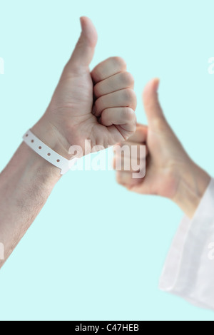 En premier plan : man main thumb up victoire, contexte : médecin ou infirmière thumb up, cette image symbolise 'J'ai gagné la lutte' Banque D'Images