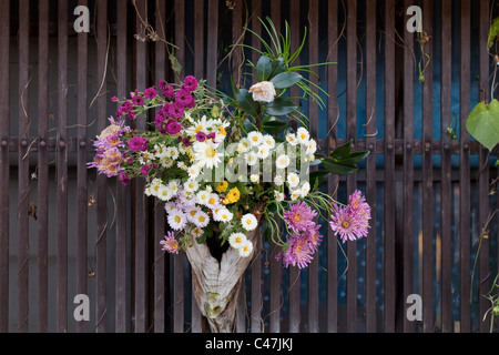 Les fleurs fraîches accroché à un bâtiment traditionnel en bois sur Nakasendo post road, Tsumago, la vallée de Kiso, Nagano, Honshu, Japon. Banque D'Images