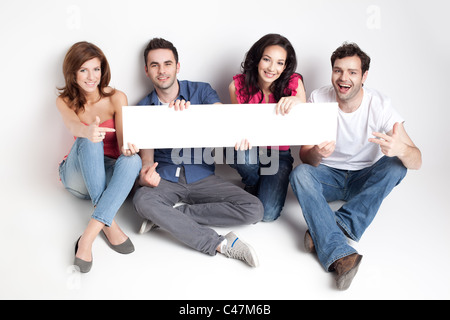 Quatre amis montrant un tableau blanc Banque D'Images