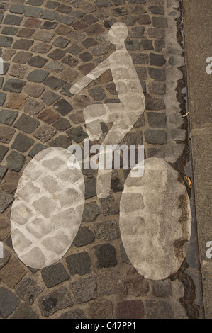 Une voie cyclable symbole peint sur les pavés d'une rue de Paris. France. Banque D'Images