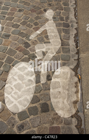 Une voie cyclable symbole peint sur les pavés d'une rue de Paris. France. Banque D'Images