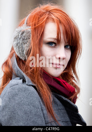 Portrait tête d'un adolescent aux cheveux de gingembre portant des couvre-oreilles en hiver froid, Londres, Angleterre, Royaume-Uni, GB. Banque D'Images