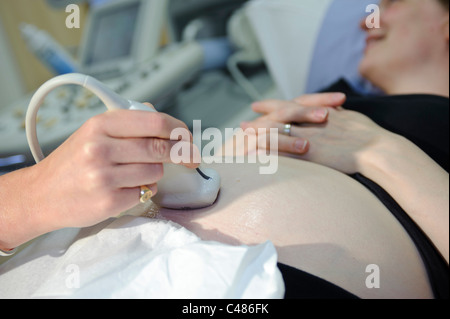 Femme enceinte sur la table de consultation du patient ayant échographie par femme médecin Banque D'Images