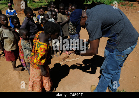 Un vidéographe Tournage avec caméra vidéo des enfants en Afrique Banque D'Images