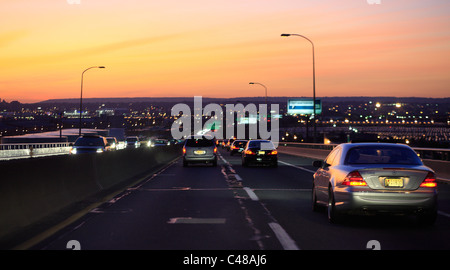 Les voitures qui circulent sur une route au coucher du soleil, Jersey City, États-Unis Banque D'Images