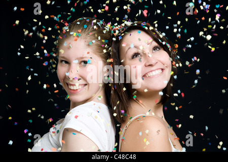 Deux jeunes femmes dans une pluie de confettis Banque D'Images