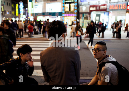 Les jeunes hommes élégants traîner près de la sortie de MRT, en attente d'amis, à Ximending, Taipei, Taiwan, le 7 novembre 2010. Banque D'Images