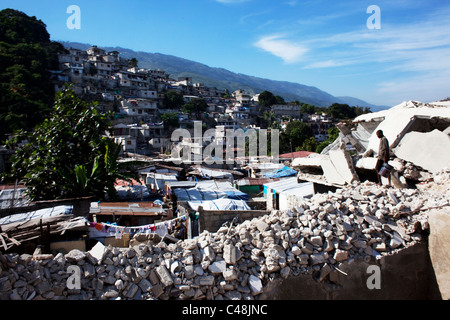 Homme marchant dans les vestiges de maisons démolies à Port-au-Prince. Banque D'Images