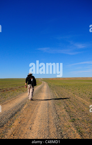 Homme marchant sur la route dans le désert de Gobi, Mongolie Banque D'Images