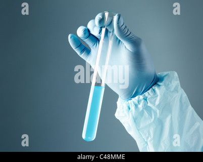 Close-up de tube de verre avec le liquide bleu dans la main pendant le test médical scientifique Banque D'Images