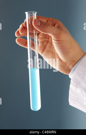 Close-up de tube de verre avec le liquide bleu dans la main pendant le test médical scientifique Banque D'Images