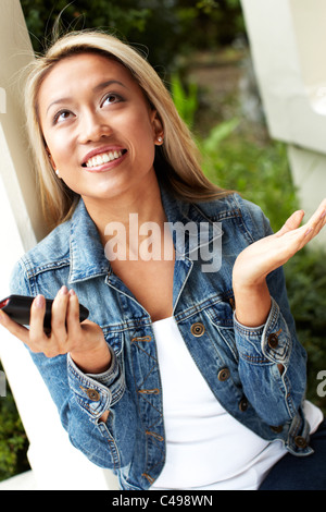 Fille de la réception du message excité sur son téléphone Banque D'Images