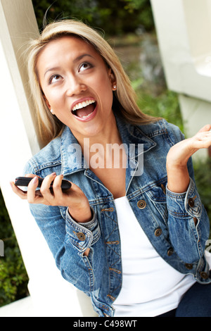 Fille de la réception du message excité sur son téléphone Banque D'Images