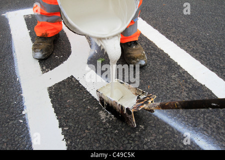 Marquage routier, piste de route, garder à l'écart, Santé et sécurité, peinture de route, Hommes au travail, peinture pour chariot, marqueur de ligne, suivant la ligne de trottoir, repère jaune. Banque D'Images