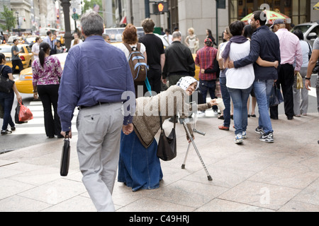 Mobilité gypsy femme mendiant sur la 5e Avenue à New York. Banque D'Images