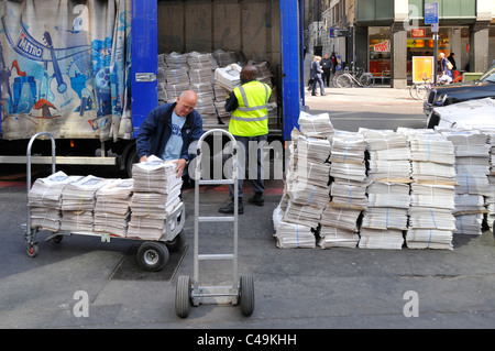 Street Scene hommes déchargement camion de la charge de Evening Standard journaux gratuits de camion garés Liverpool Street gare City of London Angleterre UK Banque D'Images