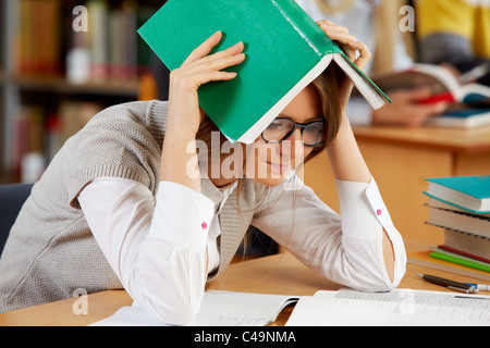 Portrait de clever student reading book in college library Banque D'Images