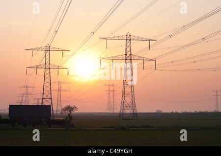 Silhouette de house et de pylônes en orange sunrise Banque D'Images