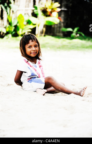 Portrait d'une jeune fille Kuna assis dans son arrière-cour sur l'île dans l'Nalunega archipel des San Blas, Panama Banque D'Images