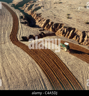 Photographie aérienne d'un tracteur laboure un champ dans le nord du désert du Néguev Banque D'Images
