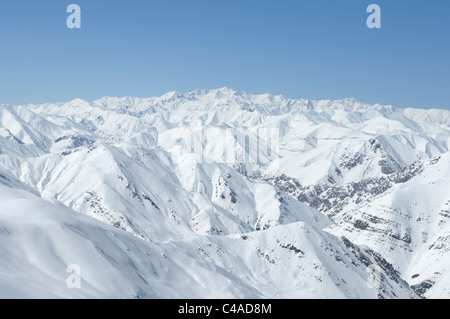 La recherche à travers la chaîne de montagnes Alborz couvertes de neige en hiver dans le nord de l'Iran vers Alam-Kuh au loin. Banque D'Images