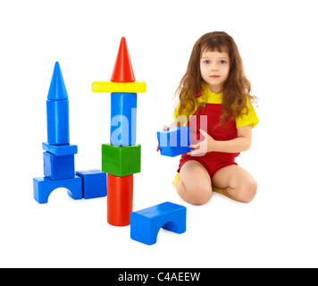 L'enfant construit un château de jouet sur le plancher isolé sur fond blanc Banque D'Images