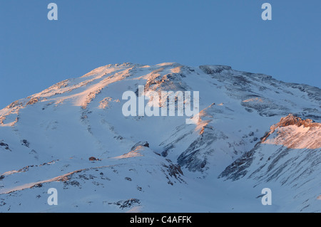 Les pentes d'un Mont Damavand couvert de neige dans les montagnes de l'Alborz Iran baigné dans alpenflow Banque D'Images