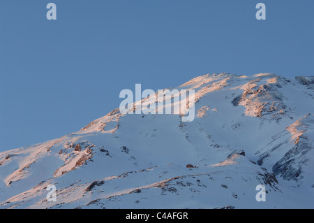 Les pentes d'un Mont Damavand couvert de neige dans les montagnes de l'Alborz Iran baigné dans alpenflow Banque D'Images