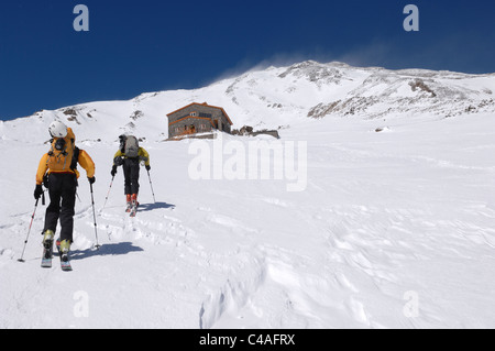 Un homme de l'écorcher le haut de la colline tout en ski de randonnée en altitude sur le mont Damavand un volcan en montagnes Alborz Iran Banque D'Images