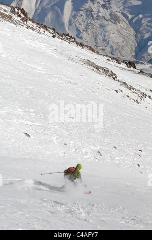 Un homme portant un sac à dos de ski hors piste dans la neige sous un ciel bleu sur le mont Damavand partie des montagnes Alborz Iran Banque D'Images