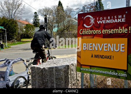 Remorque enfant cycliste dans le motion blur sur piste cyclable passant Bienvenue Inscription collectivité des Premières Nations de Wendake Banque D'Images