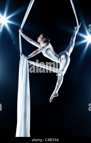 Jeune femme gymnaste. Sur fond noir avec effet flash. Banque D'Images
