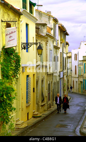 Arles, Bouches du Rhône, France ; un couple en train de marcher dans une rue typique de la ville Banque D'Images