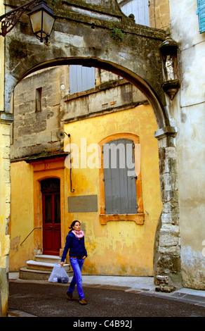 Arles, Bouches du Rhône, France ; une jeune femme marchant le long des vieilles rues. M. Banque D'Images