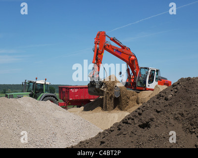 Pelle pelle le chargement d'un camion benne avec la masse sur un chantier près de Tespe, Basse-Saxe, Allemagne Banque D'Images
