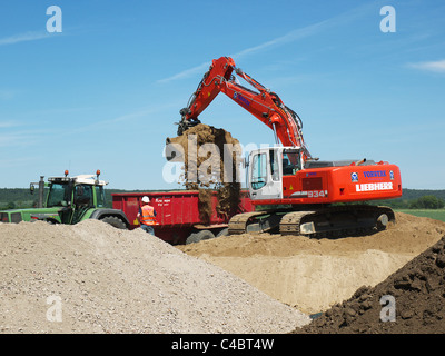 Pelle pelle le chargement d'un camion benne avec la masse sur un chantier près de Tespe, Basse-Saxe, Allemagne Banque D'Images