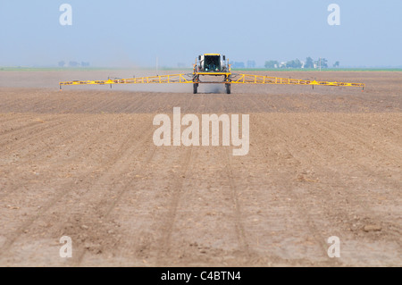 Pulvérisation pulvérisateur automoteur ou herbicide insecticide sur un champ agricole émergente. Banque D'Images