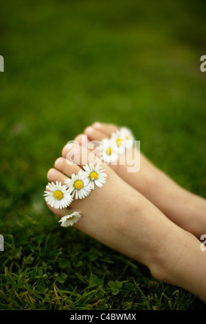 Petite fille de cinq ans avec daisies entre ses orteils Banque D'Images