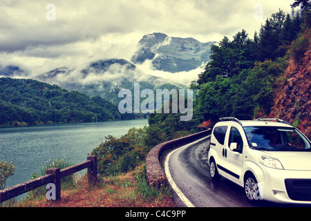 La voiture sur la route par le lac avant la tempête en Toscane Banque D'Images