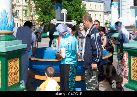 Personnes remplissant leurs bouteilles d'eau bénite de la fontaine à la Trinity Monastère de Saint Serge à Serguiev Posad, Russie Banque D'Images