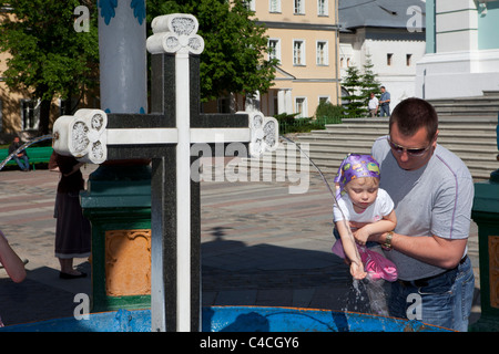 Petite fille de boire de l'eau bénite de la fontaine à la Trinity Monastère de Saint Serge à Serguiev Posad, Russie Banque D'Images