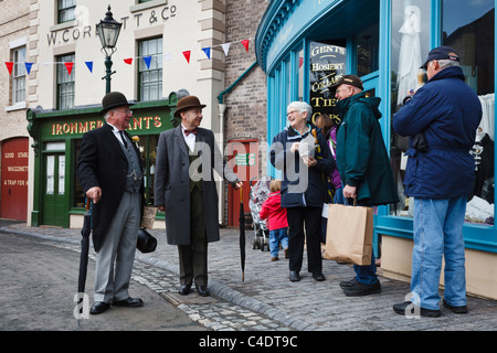 Les visiteurs de Blists Hill Victorian Town dans la région de Ironbridge chat aux personnages en costume d'époque. Banque D'Images