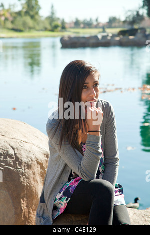 Hispanic girl sitting in nature réfléchie sérieusement penser rêver assis à méditer sérieusement monsieur © Myrleen Pearson Banque D'Images